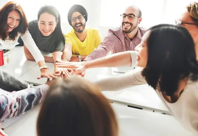 A group of professionals doing a hand stack during a meeting.